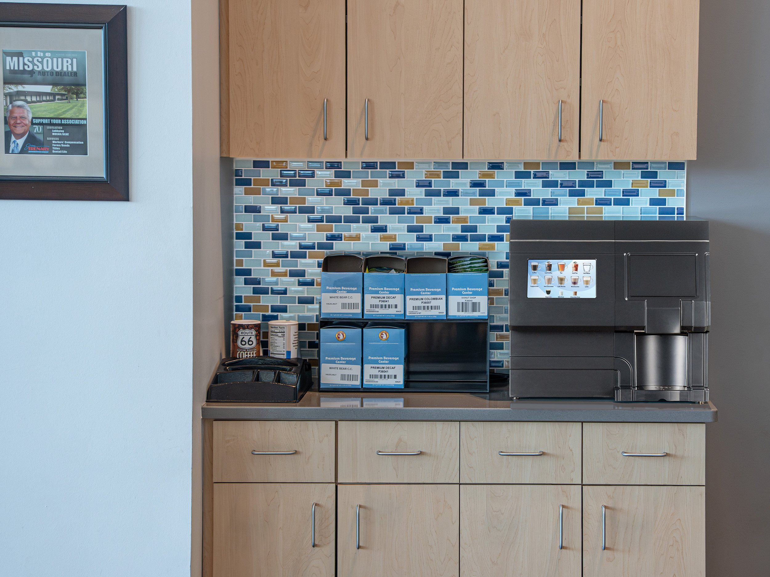 CX Touch Horizon Countertop A black CX-Touch sits on a kitchenette counter next to a selection of blue coffee pods.