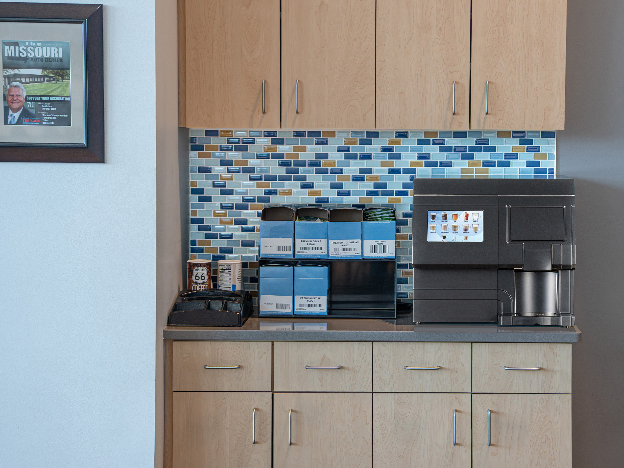 CX Touch Horizon Countertop A black CX-Touch sits on a kitchenette counter next to a selection of blue coffee pods.