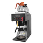 Angle View of stainless steel cabinet, hot water faucet, one lower burner, two upper burners FC-S3 brewer, shown with three glass carafes